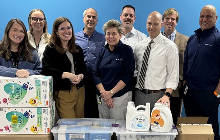 The RELI Group team standing in front of donations for local organizations