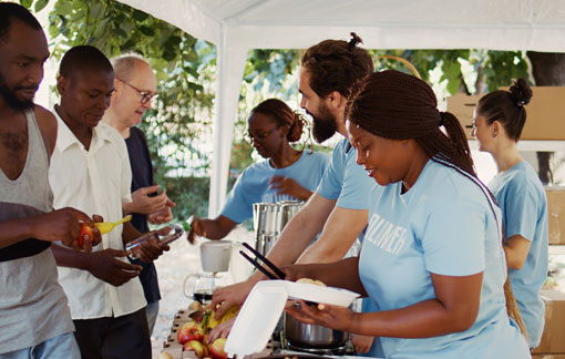 Elias and Sultana team serving food to people waiting in line