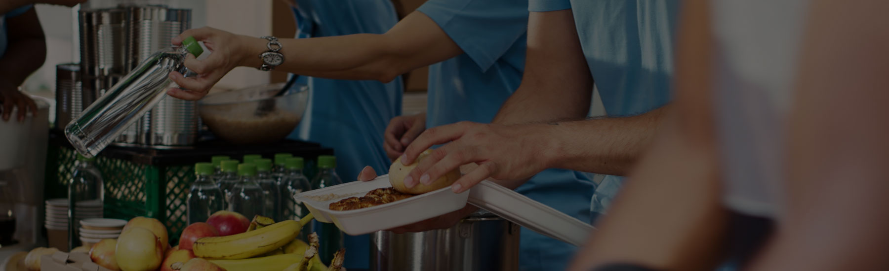 Slightly opaque overlay on top of image of Foundation volunteers handing out food at charitable event